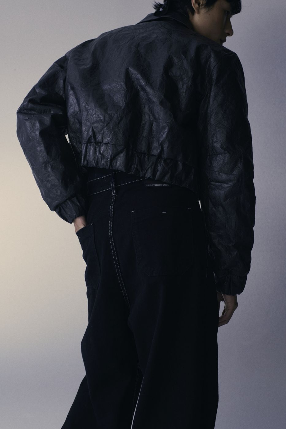 Lưng áo da nhăn, quần denim đen